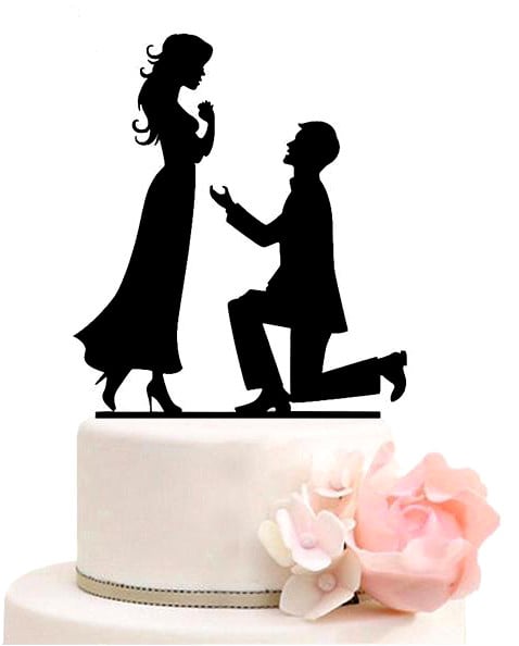 On one knee. Wedding cake topper. Black silhouette.